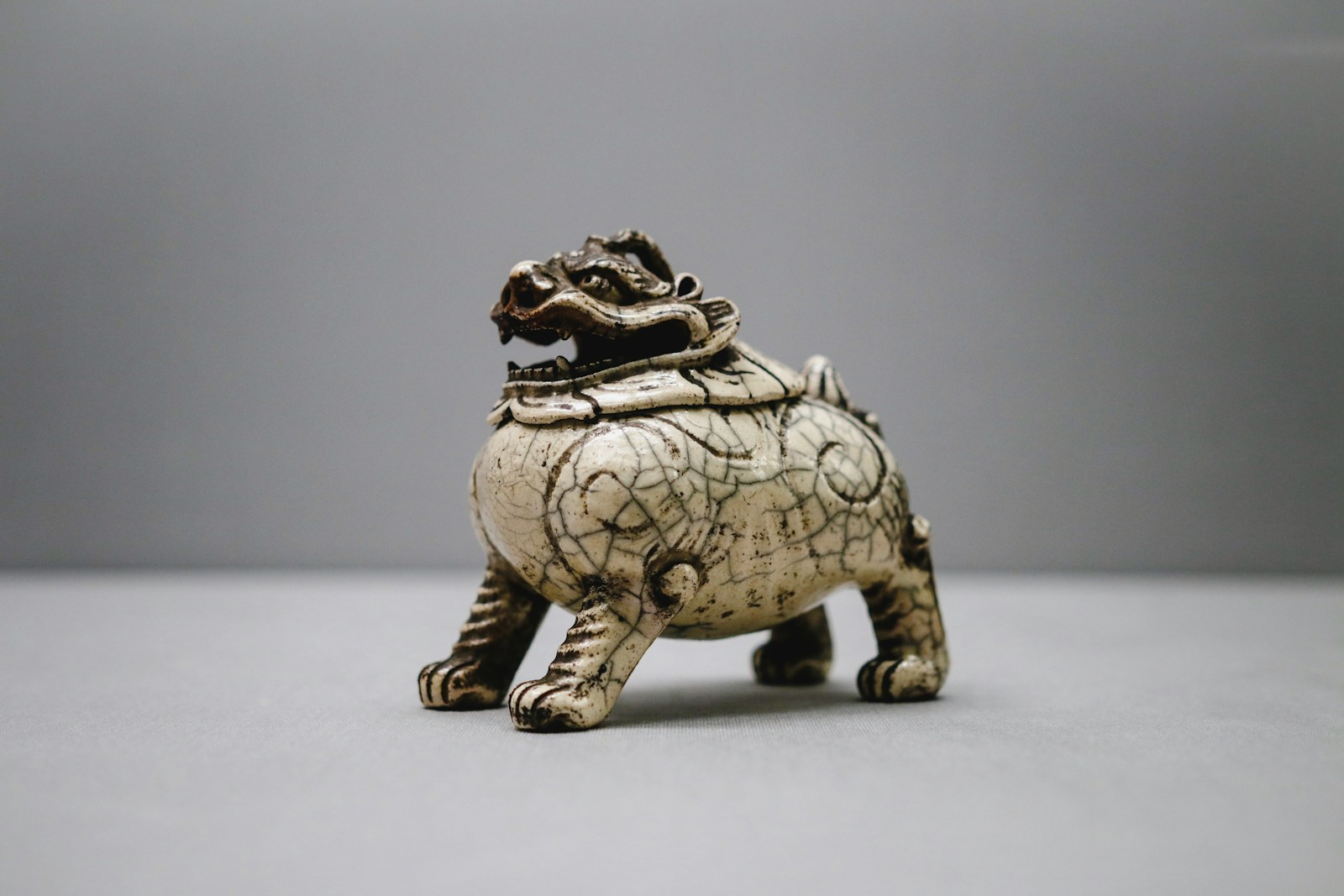 gray ceramic foo-dog figurine on white surface