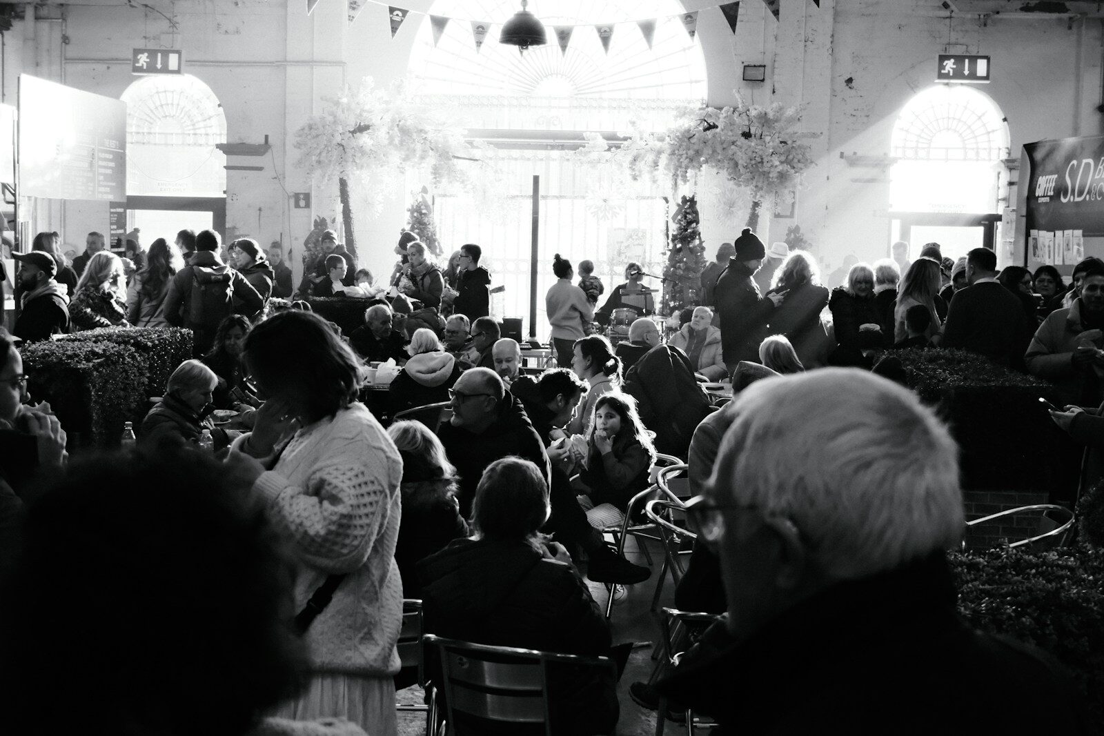 Crowd gathered inside a large hall with decorations.